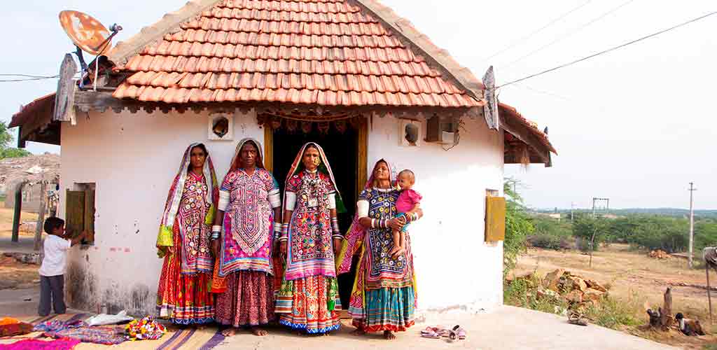 Tribal women in front of their hut, Kutch, Gujarat, India.