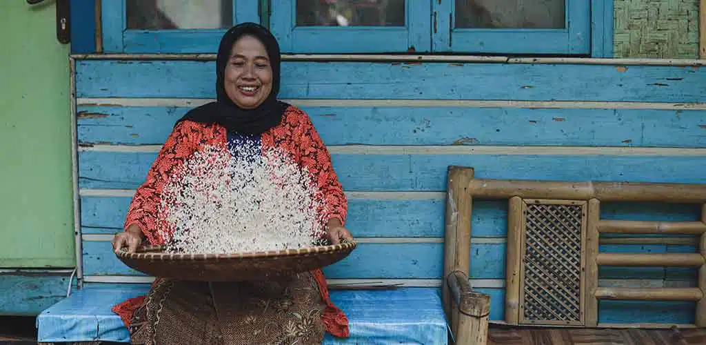 Older woman sifting rice