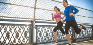 Man and Woman running on a bridge.