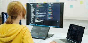 Woman sits in front of the computer and programs