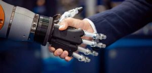 Hand of a businessman hand shakes with an android robot.